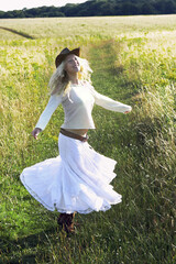 A woman with cowboy hat running on the field