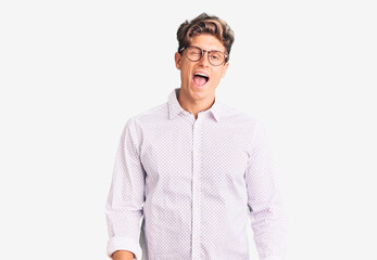 Young handsome man wearing business clothes and glasses winking looking at the camera with sexy...