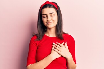 Young beautiful girl wearing casual t shirt and diadem smiling with hands on chest, eyes closed with grateful gesture on face. health concept.