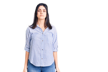 Young beautiful girl wearing striped shirt with serious expression on face. simple and natural looking at the camera.