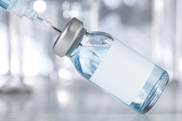 Healthcare and pharmaceutical drugs concept with syringe and vaccine vial with blue liquid. Drug...