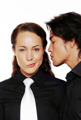 A sulking lady in black shirt and white tie being sniffed by her boyfriend