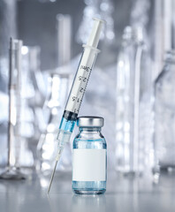 Healthcare and pharmaceutical drugs concept with syringe and vaccine vial with blue liquid. Drug...