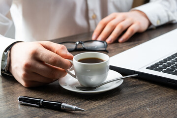 Businessman sitting at desk and drink coffee