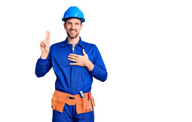 Young handsome man wearing worker uniform and hardhat smiling swearing with hand on chest and fingers up, making a loyalty promise oath