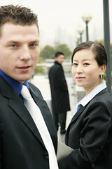 A man and a lady in business suit looking at the camera