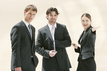A lady talking to two men in business suits