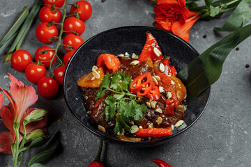Beef wok. Traditional chinese mongolian beef stir fry in chinese cast iron wok with cooking chopsticks, stone slate background. Top view, copy space