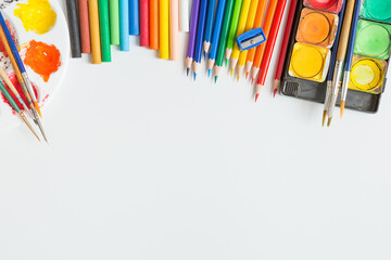 Top view of Colorful Watercolor palette, paintbrush, colored pencils, ruler and drawing equipment  on white background and copy space