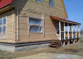 Construction of a wooden house. Wood beam, bricks. The project of a private country house.