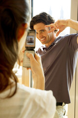 Fototapeta premium A woman taking her husband's picture with her camera phone