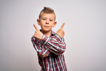 Young little caucasian kid with blue eyes wearing elegant shirt standing over isolated background Pointing to both sides with fingers, different direction disagree
