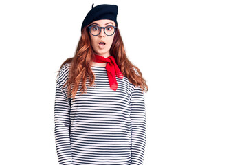 Young beautiful woman wearing french look with beret scared and amazed with open mouth for surprise, disbelief face