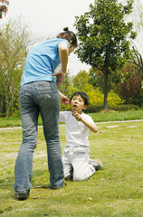 Back shot of a lady pulling his naughty brother's ear