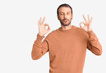 Young handsome man wearing casual clothes relax and smiling with eyes closed doing meditation gesture with fingers. yoga concept.