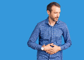 Young handsome man wearing casual clothes with hand on stomach because indigestion, painful illness...