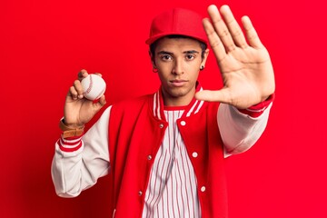 Young african amercian man wearing baseball uniform holding ball with open hand doing stop sign with serious and confident expression, defense gesture