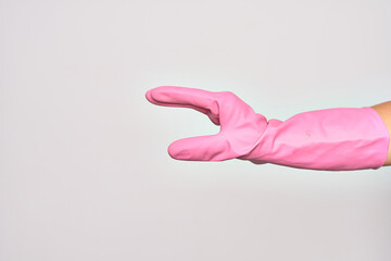 Hand of caucasian young woman wearing pink cleaning glove doing catch sign over isolated white background