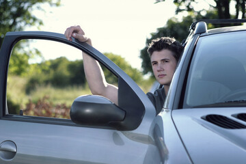 A guy looking out from an opened car door