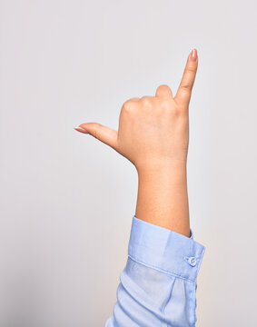 Hand of caucasian young woman doing surf salutation. Showing fingers doing telephone sign over isolated white background