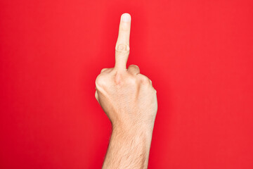 Hand of caucasian young man showing fingers over isolated red background showing provocative and...