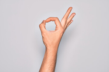 Hand of caucasian young man showing fingers over isolated white background gesturing approval...