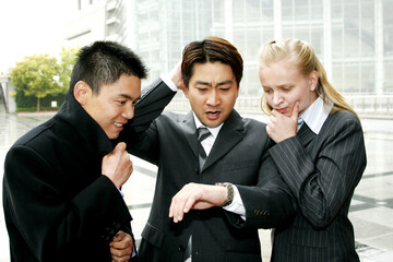 A group of business people looking at the time