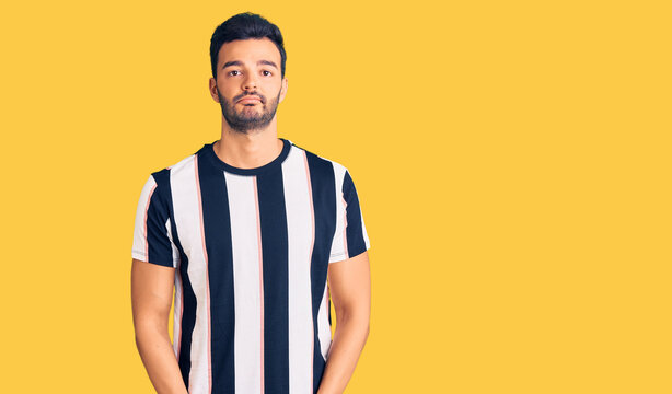 Young handsome hispanic man wearing striped tshirt depressed and worry for distress, crying angry and afraid. sad expression.