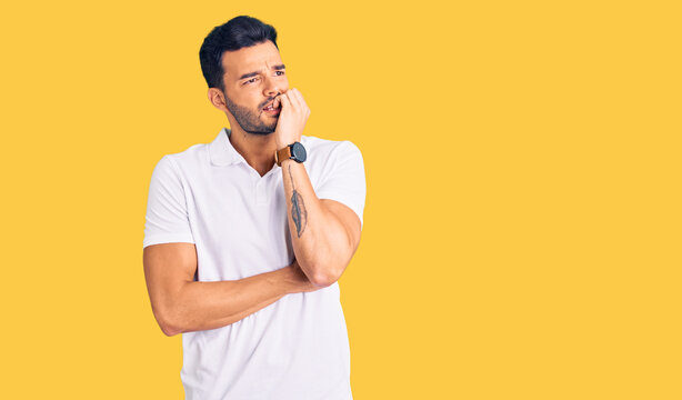 Young handsome hispanic man wearing casual clothes looking stressed and nervous with hands on mouth biting nails. anxiety problem.