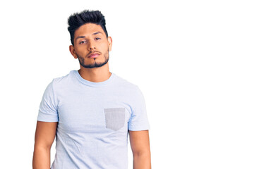 Fototapeta premium Handsome latin american young man wearing casual clothes relaxed with serious expression on face. simple and natural looking at the camera.