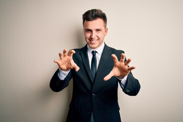 Young handsome business man wearing elegant suit and tie over isolated background smiling funny...