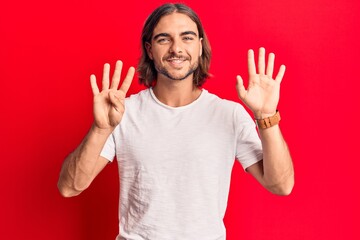 Young handsome man wearing casual clothes showing and pointing up with fingers number nine while...