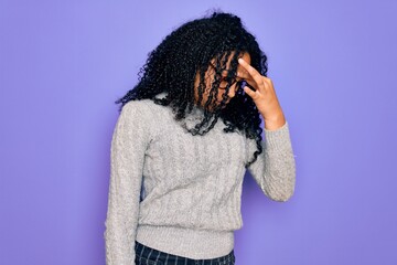 Young african american woman wearing casual sweater and glasses over purple background tired rubbing nose and eyes feeling fatigue and headache. Stress and frustration concept.