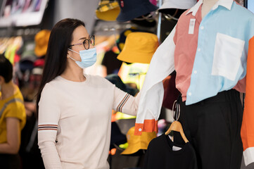 Shopping is a major pastime in Asian regions woman wearing face mask shopping in department store...