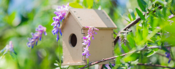 Cute wooden toy bird house in the cute violet blue flowers