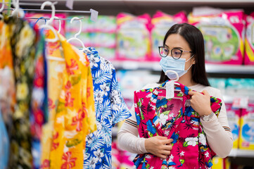 Shopping is a major pastime in Asian regions woman wearing face mask shopping in department store...