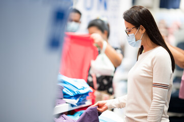 Shopping is a major pastime in Asian regions woman wearing face mask shopping in department store...
