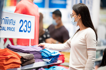 Shopping is a major pastime in Asian regions woman wearing face mask shopping in department store...