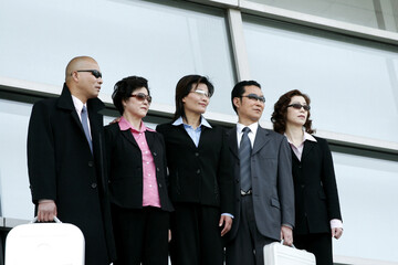 Business men and women in sunglasses standing in a row