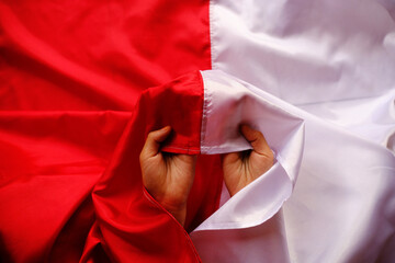 Hand holding national Indonesia Flag red and white. Indonesian Independence Day in August.