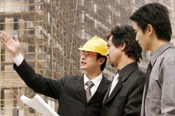Architect discussing a building plan with his client at a construction site