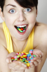 Woman with handful and mouthful of candies