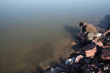 The fisherman lets out the carp in the lake. Carpfishing, sport fishing