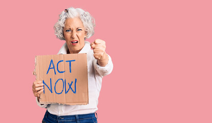 Senior grey-haired woman holding act now banner annoyed and frustrated shouting with anger, yelling...