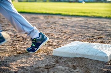 Youth baseball with a runner taking off for the next base