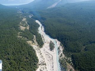 aerial view of a river in the forest with hills around