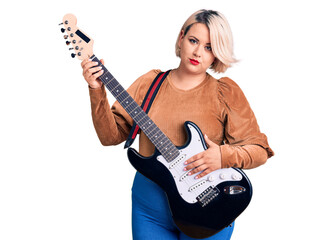 Young blonde plus size woman playing electric guitar thinking attitude and sober expression looking self confident