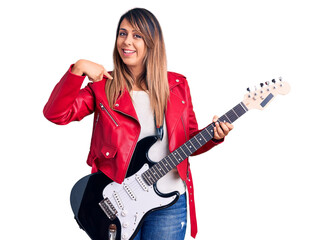 Fototapeta premium Young beautiful woman playing electric guitar pointing finger to one self smiling happy and proud