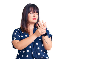 Young plus size woman wearing casual clothes suffering pain on hands and fingers, arthritis...
