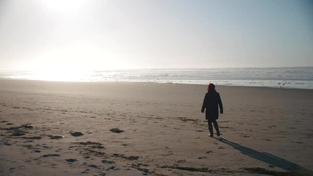 4k slow motion footage of woman walking alone on an empty beach while sunset - introverted - alone - enjoying freedom.